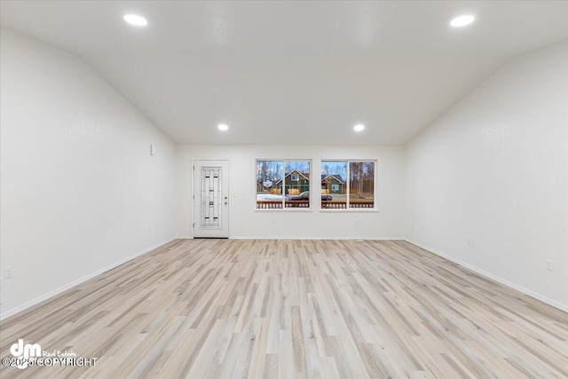 unfurnished living room with vaulted ceiling and light hardwood / wood-style flooring