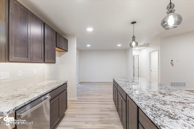 kitchen with light stone countertops, stainless steel dishwasher, light wood-type flooring, and decorative backsplash