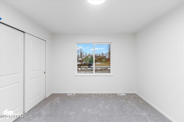 unfurnished bedroom featuring carpet and a closet