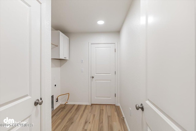 laundry area featuring cabinets and light hardwood / wood-style floors