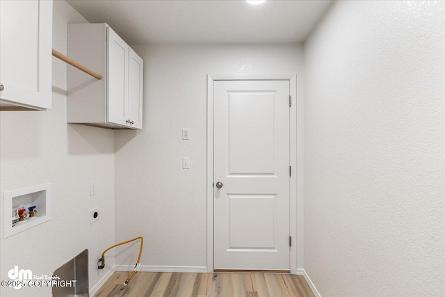 laundry room featuring cabinets, hookup for a washing machine, light hardwood / wood-style floors, and electric dryer hookup