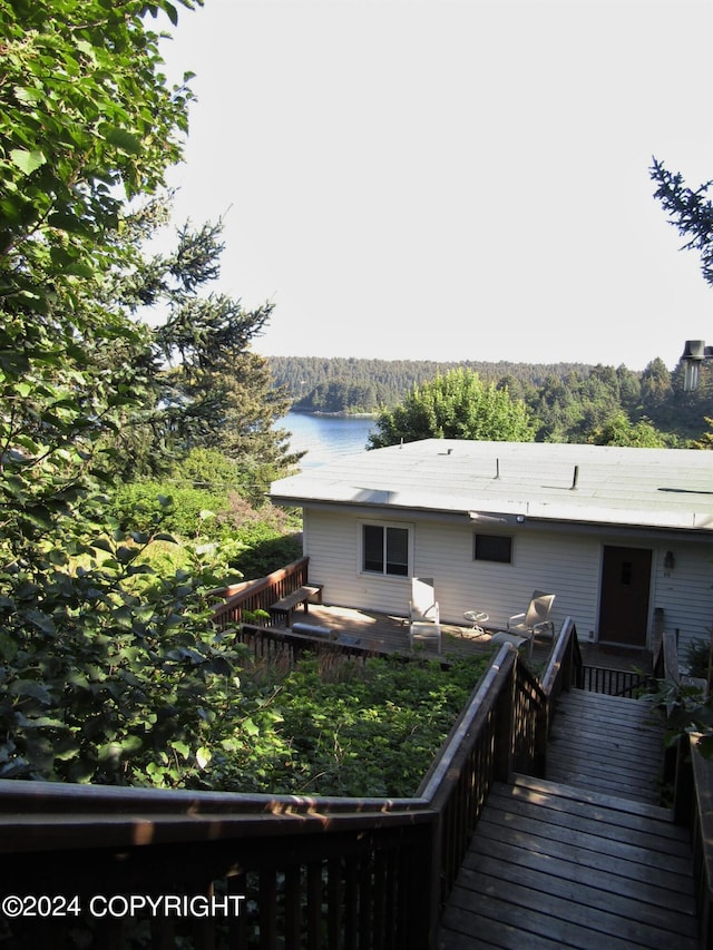 rear view of house with a deck with water view