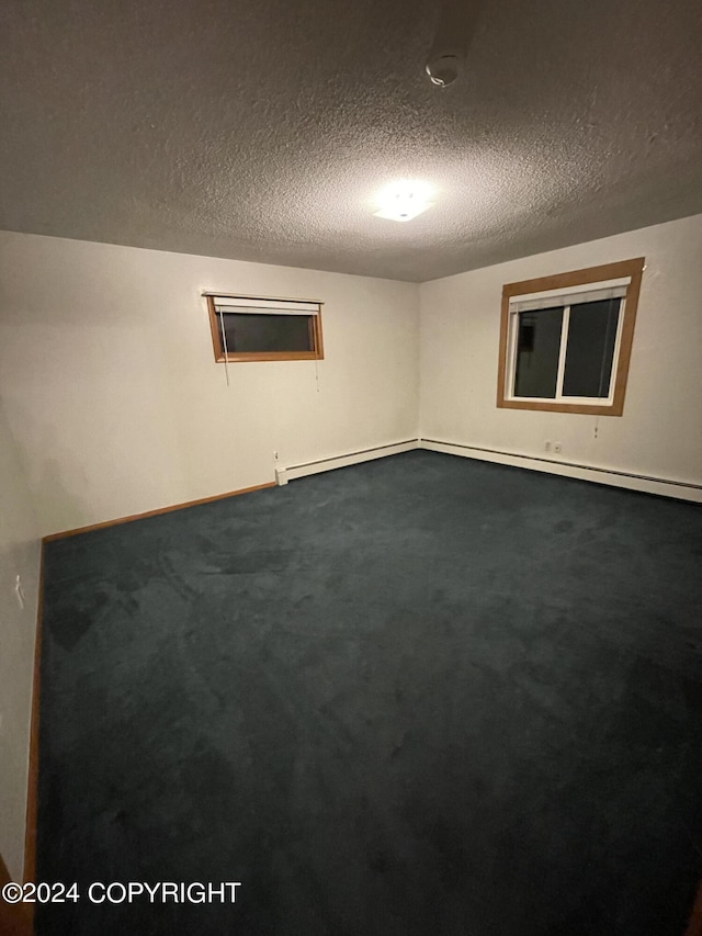 carpeted empty room featuring a textured ceiling