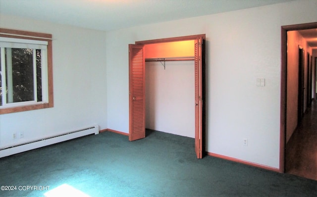 unfurnished bedroom with dark colored carpet, a baseboard heating unit, and a closet