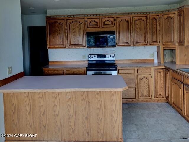 kitchen with electric stove and tasteful backsplash