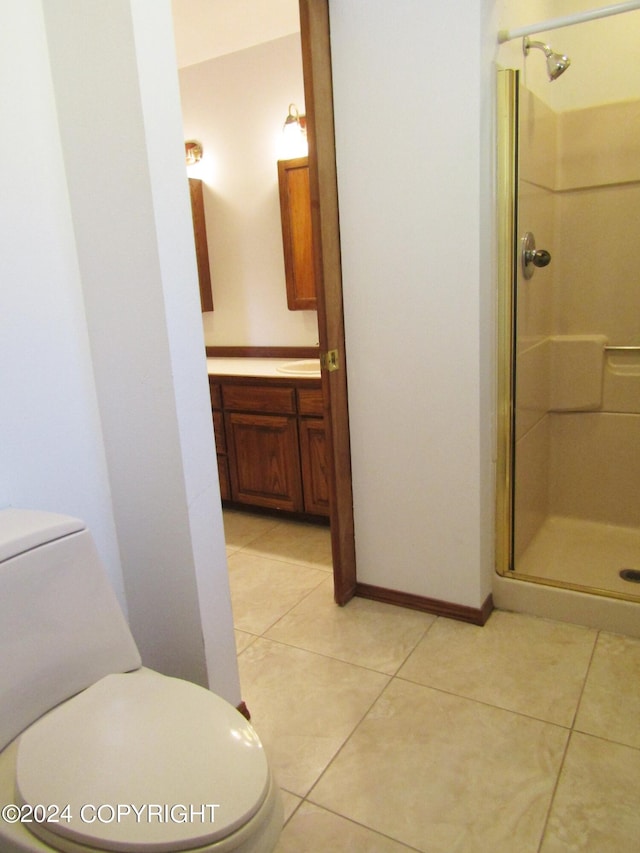 bathroom with an enclosed shower, vanity, tile patterned flooring, and toilet