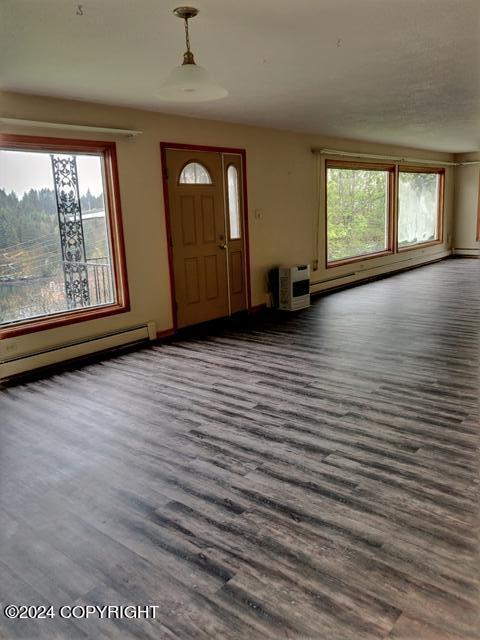 entryway with dark wood-type flooring, heating unit, and a baseboard heating unit