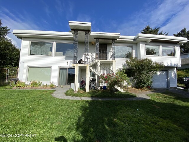 multi unit property featuring a garage and a front lawn