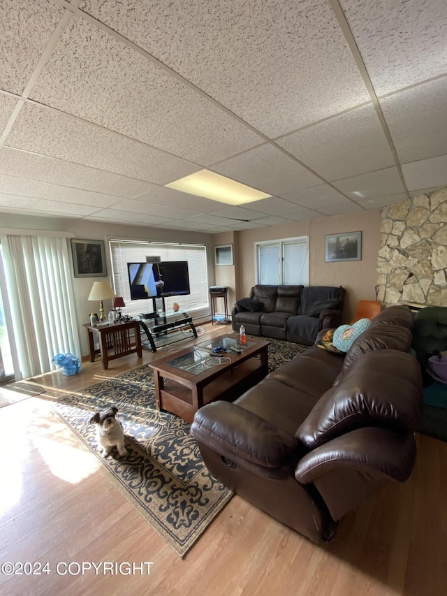 living room with a drop ceiling and wood-type flooring