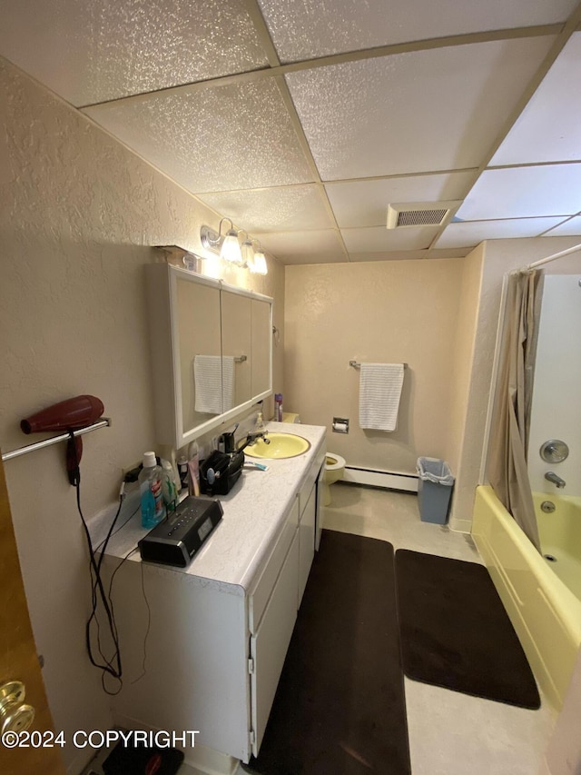 full bathroom with a paneled ceiling, a baseboard heating unit, vanity, shower / bathtub combination, and toilet