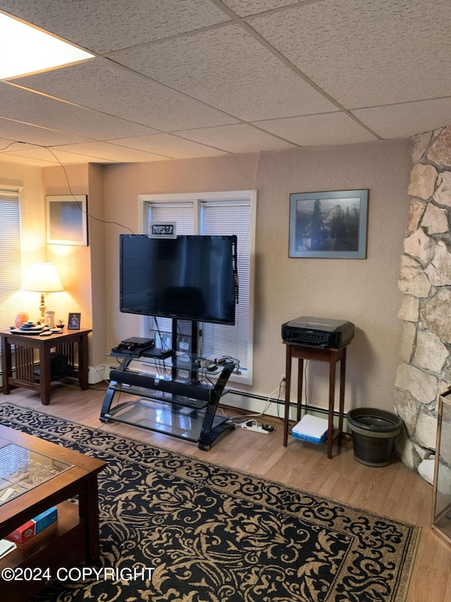 living room with hardwood / wood-style floors and a drop ceiling