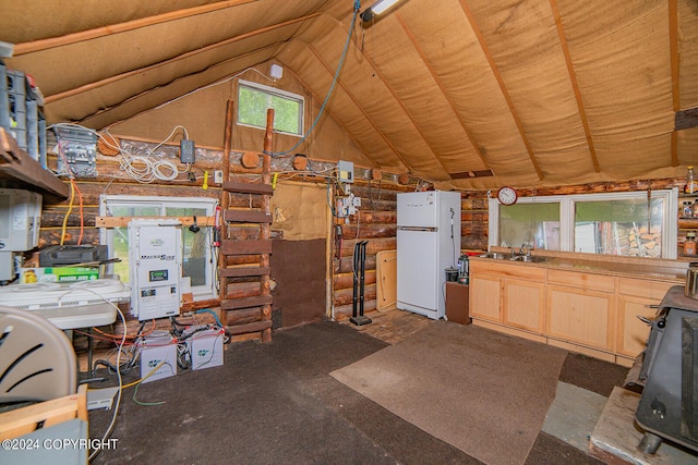 kitchen with freestanding refrigerator, vaulted ceiling, a sink, and light brown cabinetry