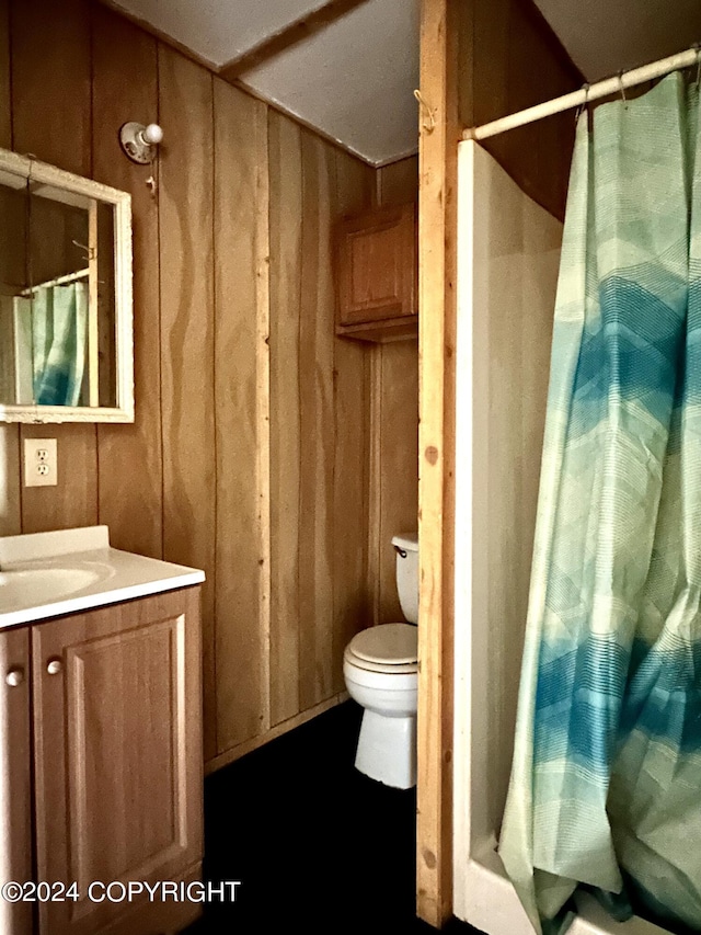 full bathroom with vanity, a shower with shower curtain, and wooden walls
