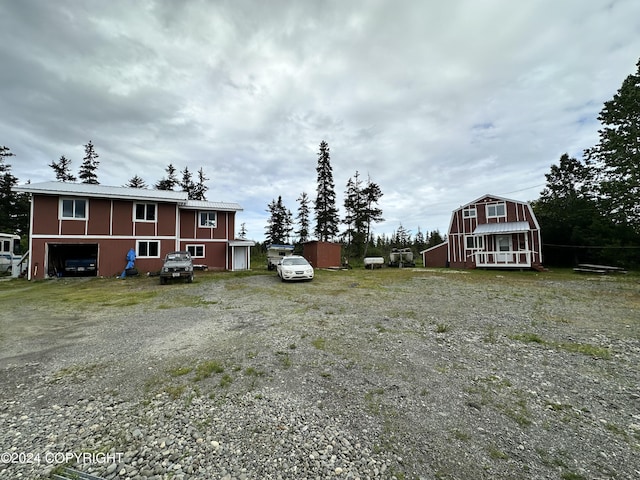 view of yard with driveway and an outbuilding