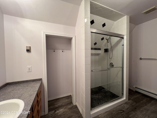 full bath featuring a stall shower, visible vents, a baseboard radiator, wood finished floors, and vanity