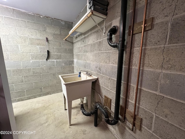 bathroom featuring concrete floors and concrete block wall