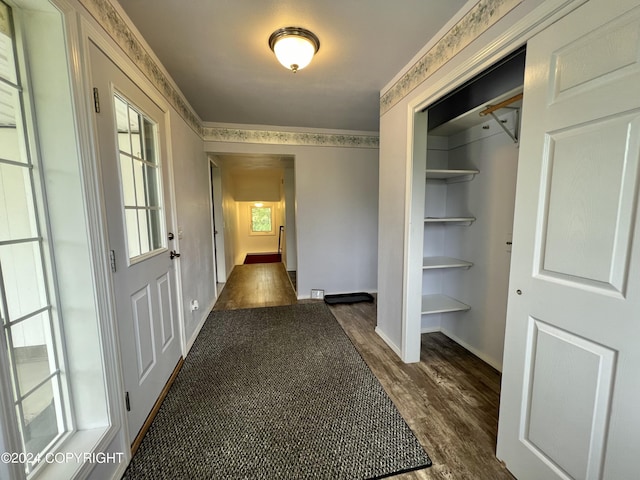 hall with dark wood-style floors, baseboards, and ornamental molding