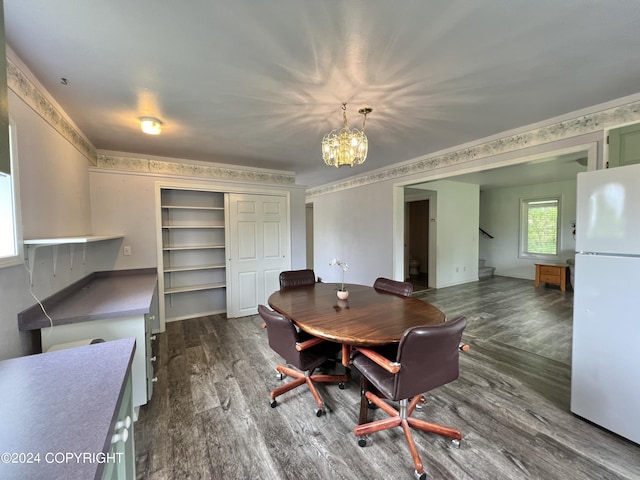 dining area featuring dark wood-style floors, crown molding, a notable chandelier, and stairs