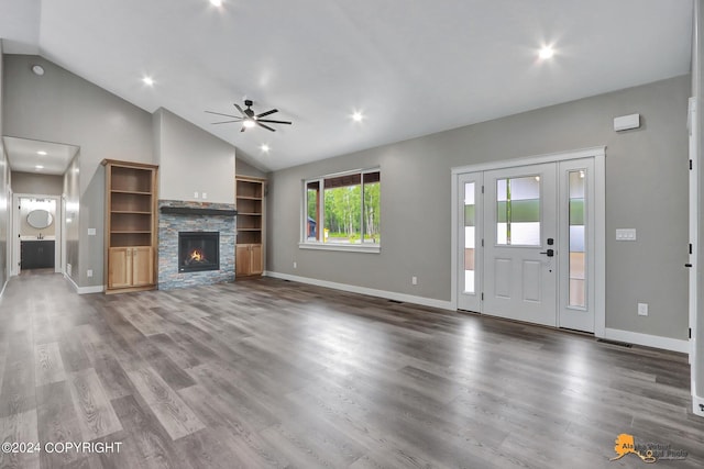 unfurnished living room with ceiling fan, lofted ceiling, hardwood / wood-style flooring, and a stone fireplace