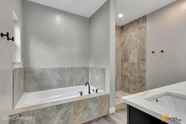 bathroom featuring hardwood / wood-style floors, vanity, and independent shower and bath