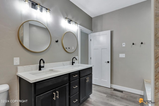 bathroom featuring hardwood / wood-style flooring, toilet, and vanity