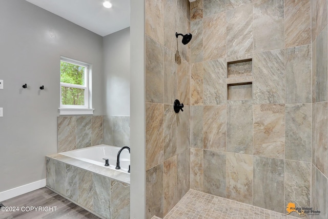 bathroom with hardwood / wood-style floors and independent shower and bath