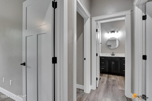 hallway featuring sink and light hardwood / wood-style floors