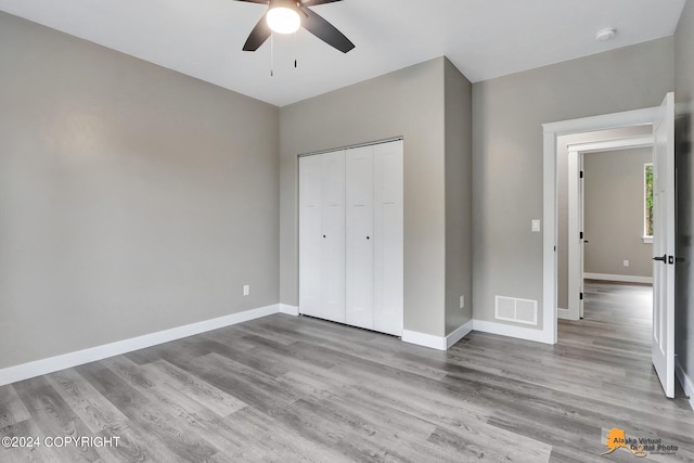 unfurnished bedroom featuring ceiling fan, a closet, and light hardwood / wood-style flooring