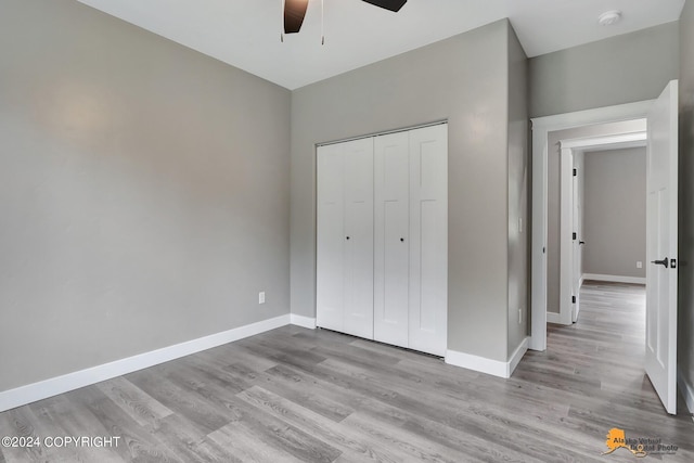 unfurnished bedroom featuring ceiling fan, light hardwood / wood-style floors, and a closet