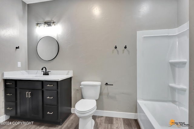 full bathroom featuring hardwood / wood-style flooring, toilet, vanity, and bathing tub / shower combination