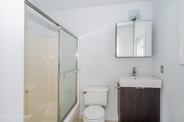 full bathroom with vanity, bath / shower combo with glass door, and toilet