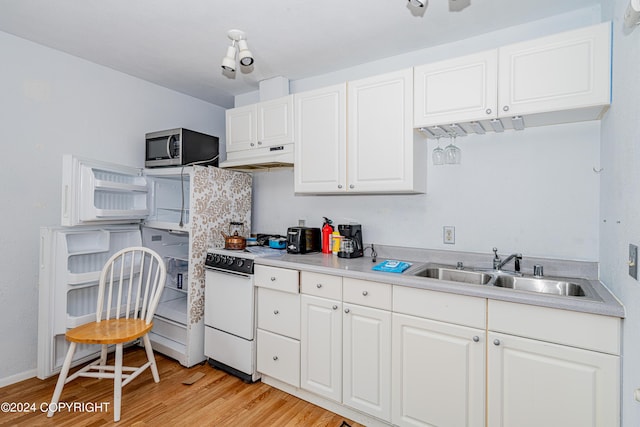 kitchen with light wood-type flooring, white range, sink, and white cabinets