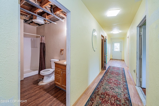 corridor featuring hardwood / wood-style floors and a textured ceiling