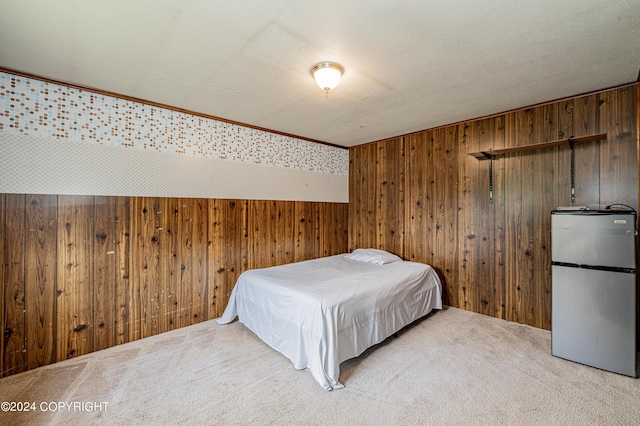 carpeted bedroom featuring a textured ceiling, stainless steel fridge, and wooden walls