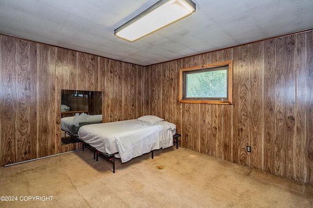 carpeted bedroom with a textured ceiling and wood walls