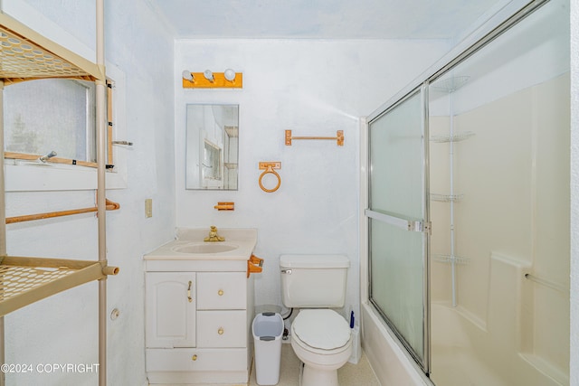 full bathroom featuring bath / shower combo with glass door, vanity, and toilet