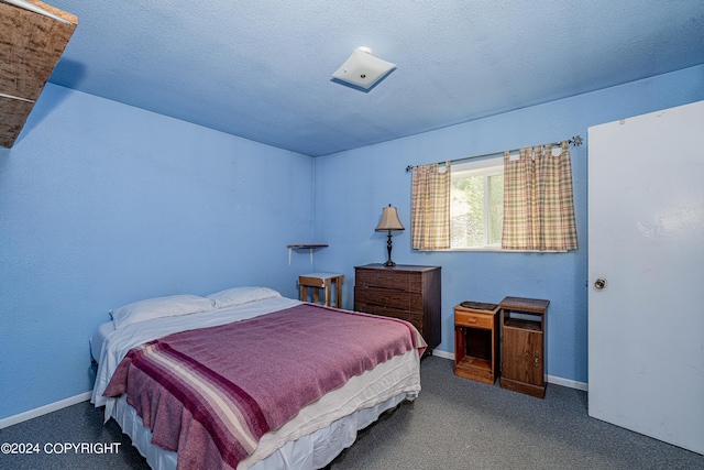 bedroom with carpet floors and a textured ceiling