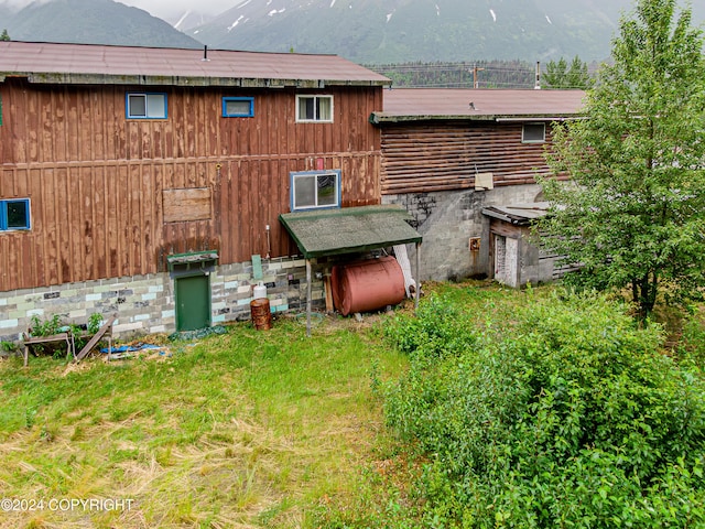 rear view of property with a mountain view and a yard