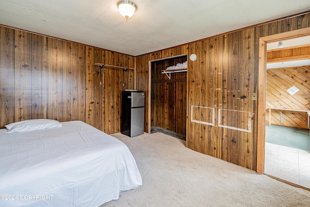 carpeted bedroom featuring stainless steel fridge, a closet, and wood walls