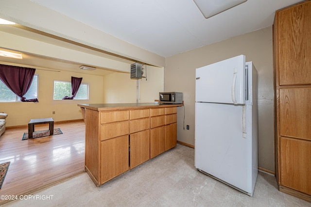 kitchen with kitchen peninsula and white fridge