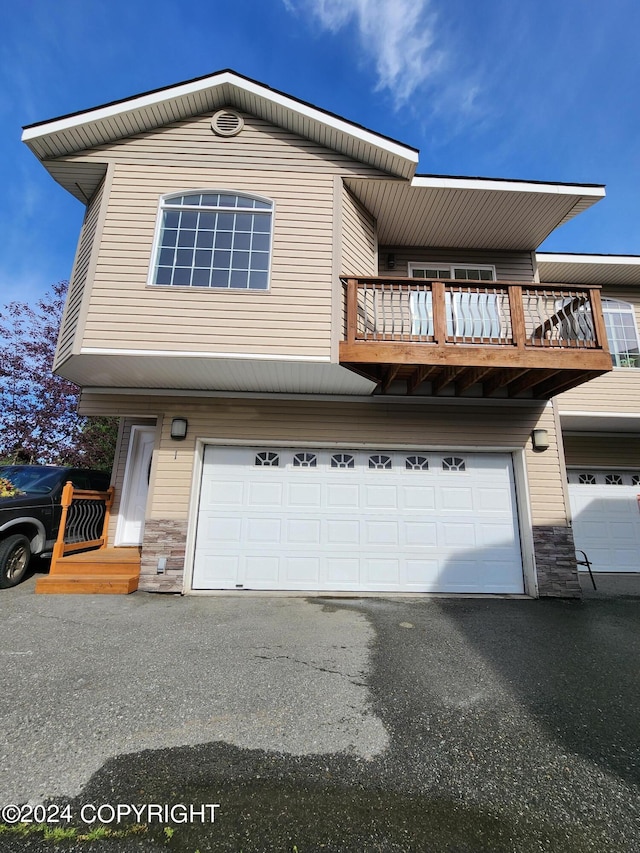 view of front of property featuring a balcony and a garage