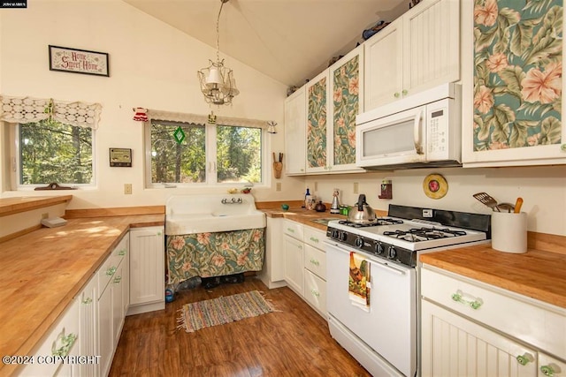 kitchen with vaulted ceiling, pendant lighting, white appliances, white cabinets, and dark hardwood / wood-style flooring