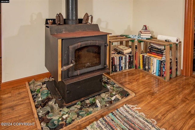 room details with a wood stove and wood-type flooring