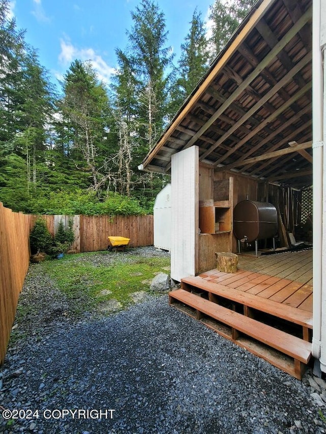 view of yard featuring a storage shed and a wooden deck