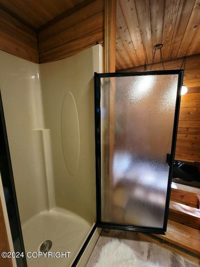 bathroom featuring walk in shower, wooden walls, wood ceiling, and wood-type flooring