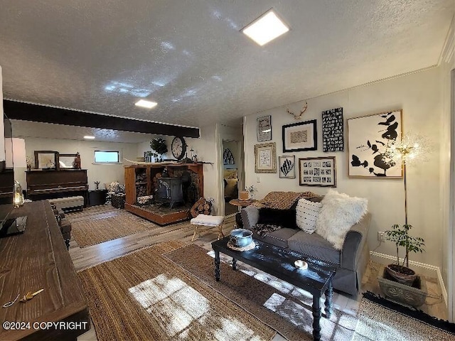 living room with a textured ceiling, hardwood / wood-style floors, and a wood stove