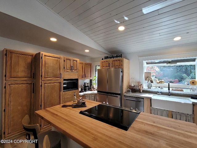 kitchen with lofted ceiling, sink, black appliances, wooden ceiling, and butcher block counters