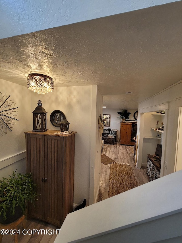 interior space with a textured ceiling and hardwood / wood-style flooring