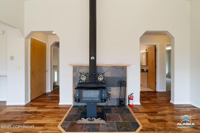 4477 Panther Dr, Eagle River, AK 99577 - detailed view of a wood stove, a fire extinguisher, wood finished floors, and baseboards