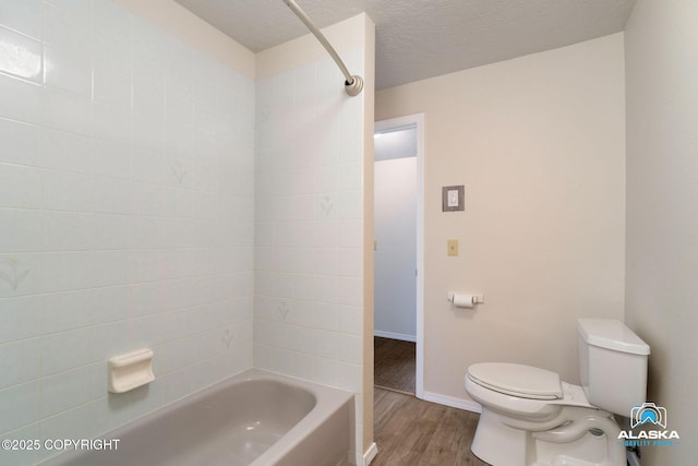 4477 Panther Dr, Eagle River, AK 99577 - bathroom with toilet, wood finished floors, shower / tub combination, baseboards, and a textured ceiling